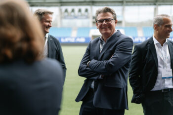 Menschen in Business Kleidung stehen auf dem Fußballfeld